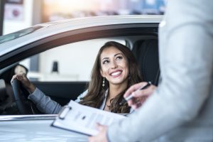 Mujer dentro de carro sonriendo